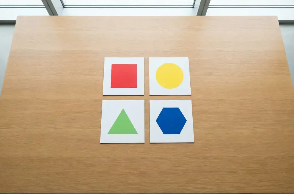 Vier gekleurde coachingkaarten in rood, geel, groen en blauw symmetrisch gerangschikt op houten conferentietafel