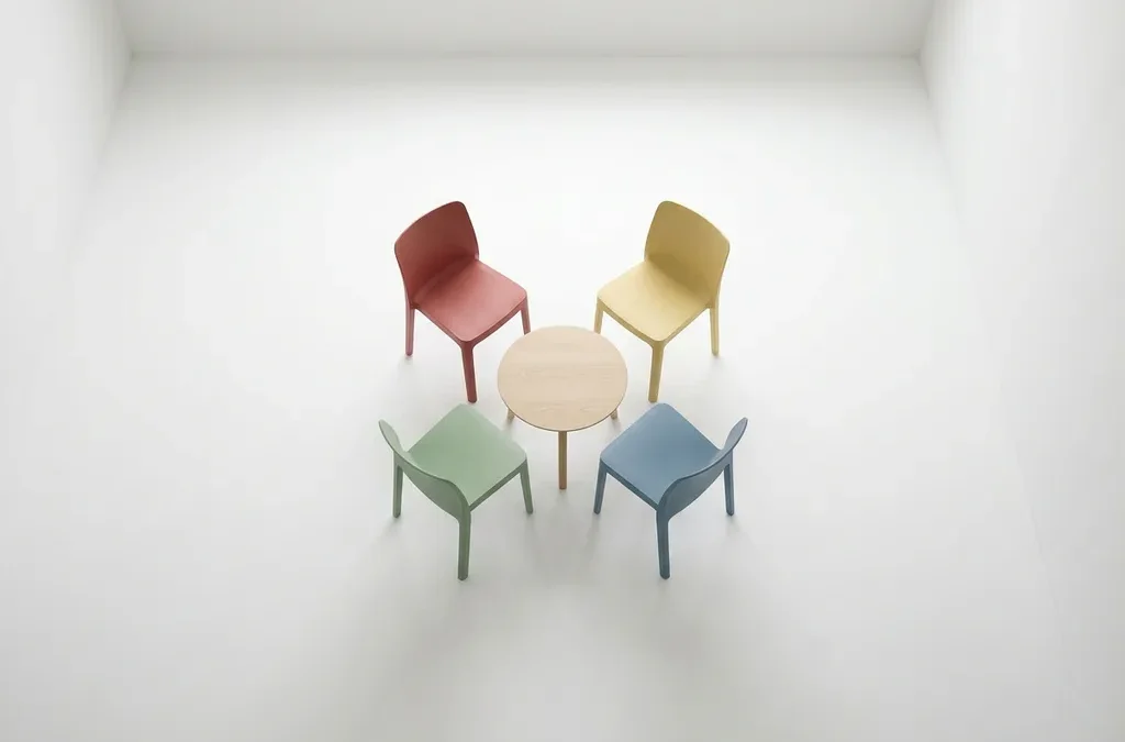 Vier lege stoelen in DISC-kleuren rood, geel, groen en blauw rond een ronde tafel, bovenaanzicht op witte achtergrond.