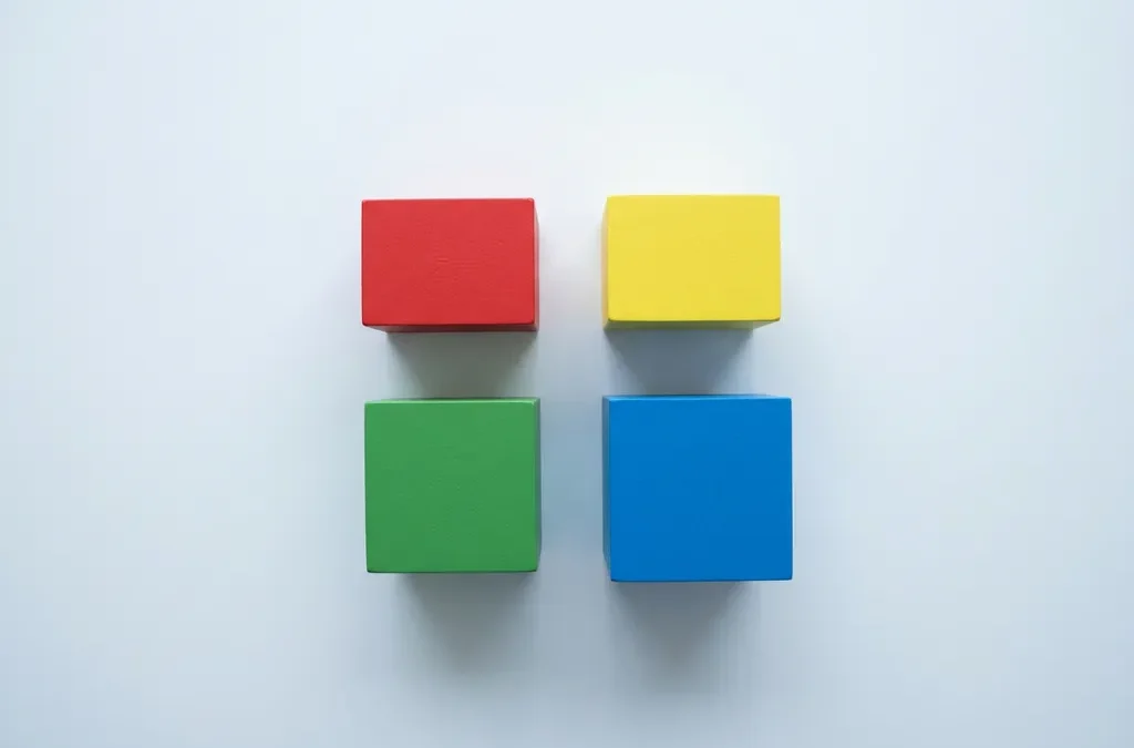 Vier gekleurde blokken in rood, geel, groen en blauw gerangschikt in een twee-bij-twee raster op een wit oppervlak.